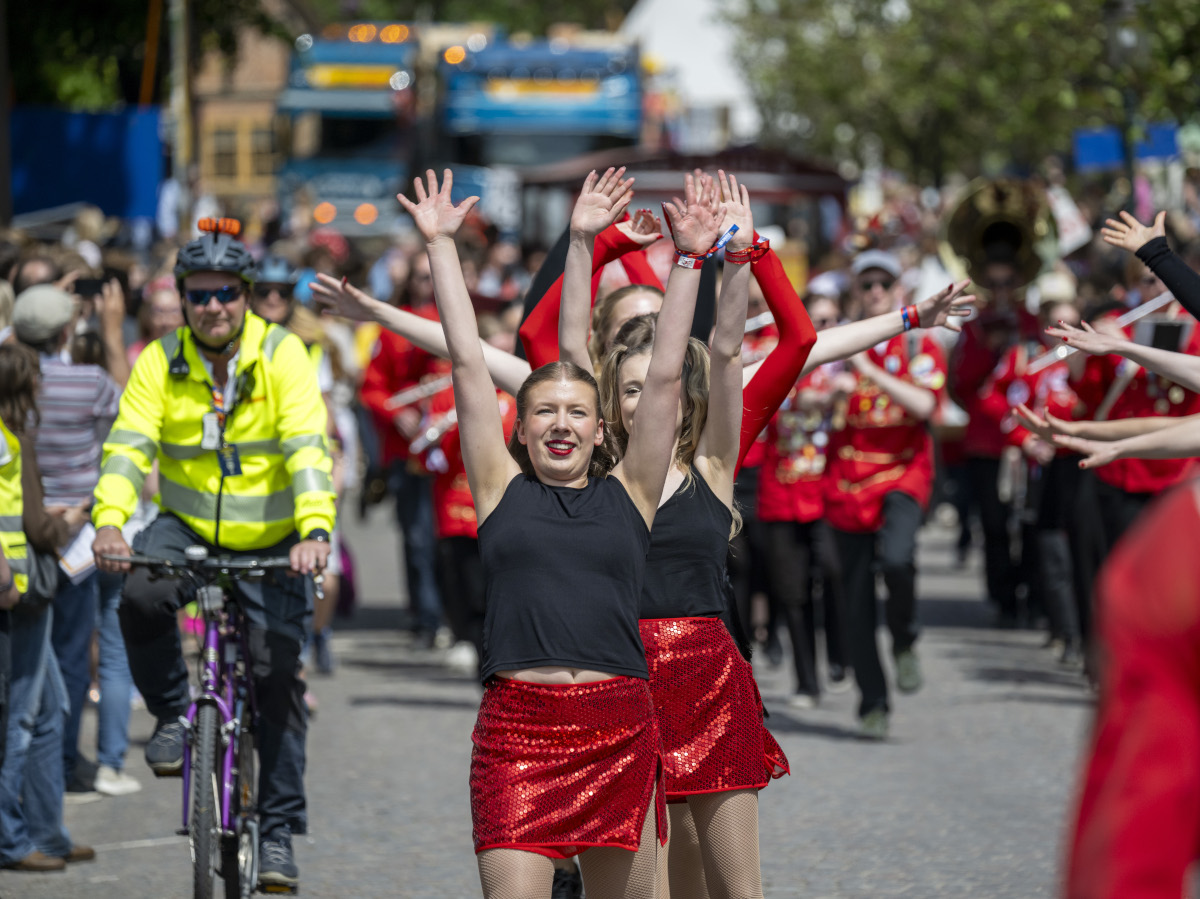 Kvinnor i röda kjolar dansar i karnevalståget i Lund.